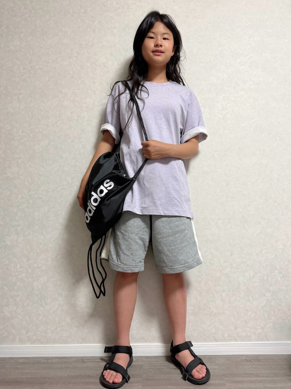 ブラック系のバックパック/リュック、ブラック系のサンダル、パープル系のTシャツ/カットソーを着用したキッズの夏コーディネートの2枚目の写真