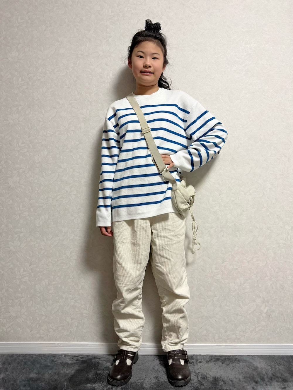 ブラウン系のその他シューズ、ホワイト系のニット/セーター、ベージュ系のステンカラーコートを着用したキッズの冬コーディネートの3枚目の写真