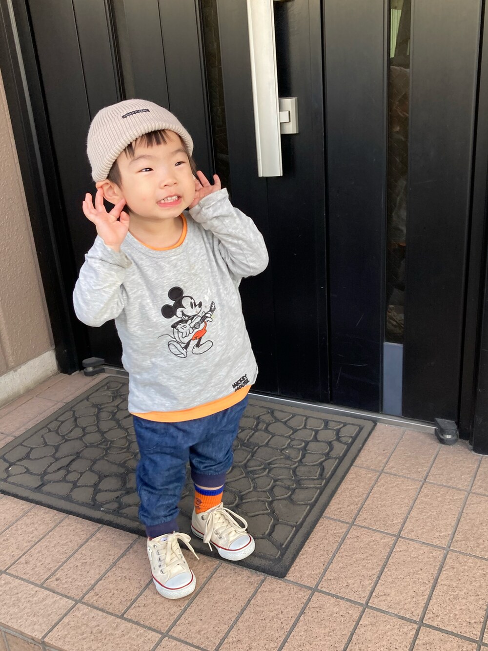 オレンジ系のタンクトップ、グレー系のTシャツ/カットソー、グレー系のナイロンジャケットを着用したキッズの春コーディネートの2枚目の写真