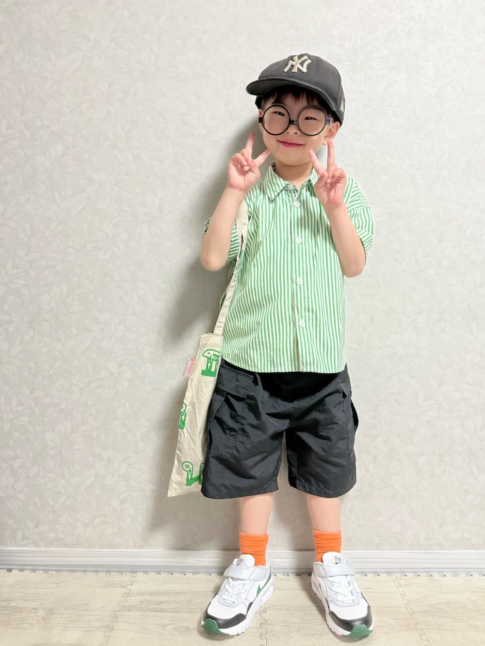 グリーン系のシャツ/ブラウス、ブラック系のカーゴパンツ、ホワイト系のスニーカーを着用したキッズの春コーディネートの2枚目の写真