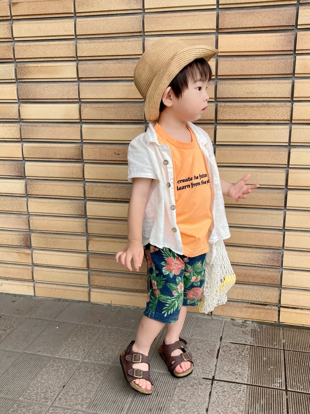 オレンジ系のタンクトップ、ベージュ系のシャツ/ブラウス、ブルー系のパンツを着用したキッズの夏コーディネートの2枚目の写真