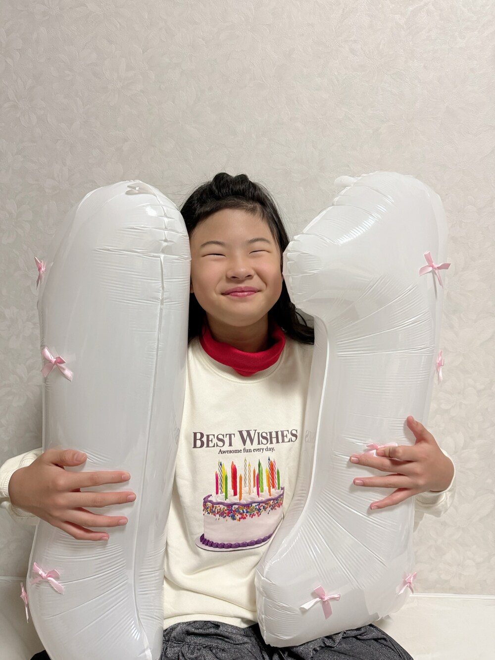 ブラック系のスカート、ホワイト系のスウェット、レッド系のTシャツ/カットソーを着用したキッズの秋コーディネートの3枚目の写真