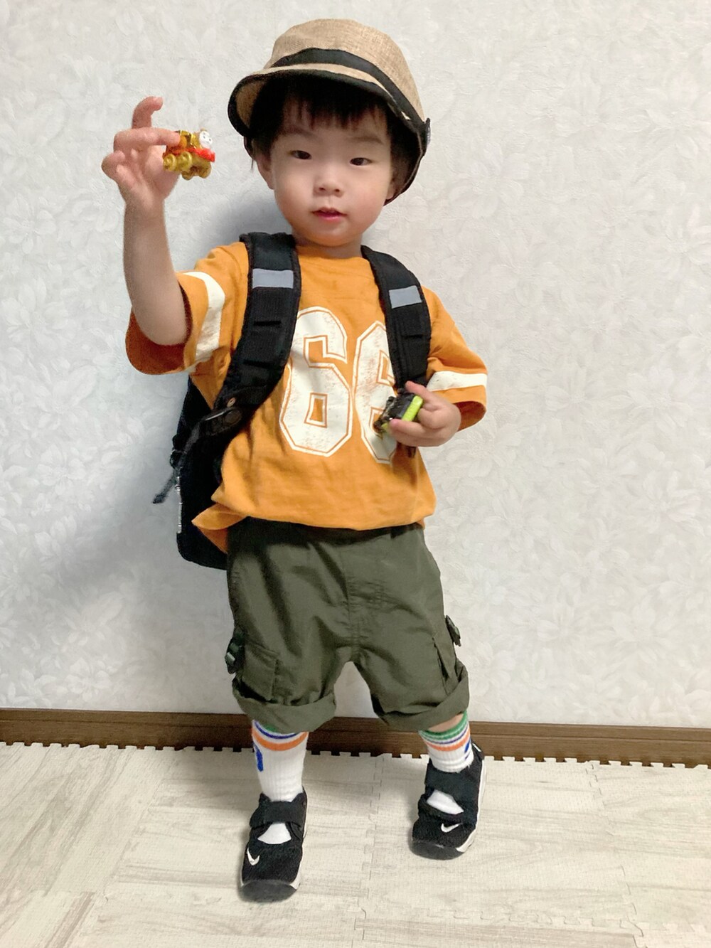 オレンジ系のTシャツ/カットソー、グリーン系のカーゴパンツ、ブラック系のスニーカーを着用したキッズの夏コーディネートの2枚目の写真