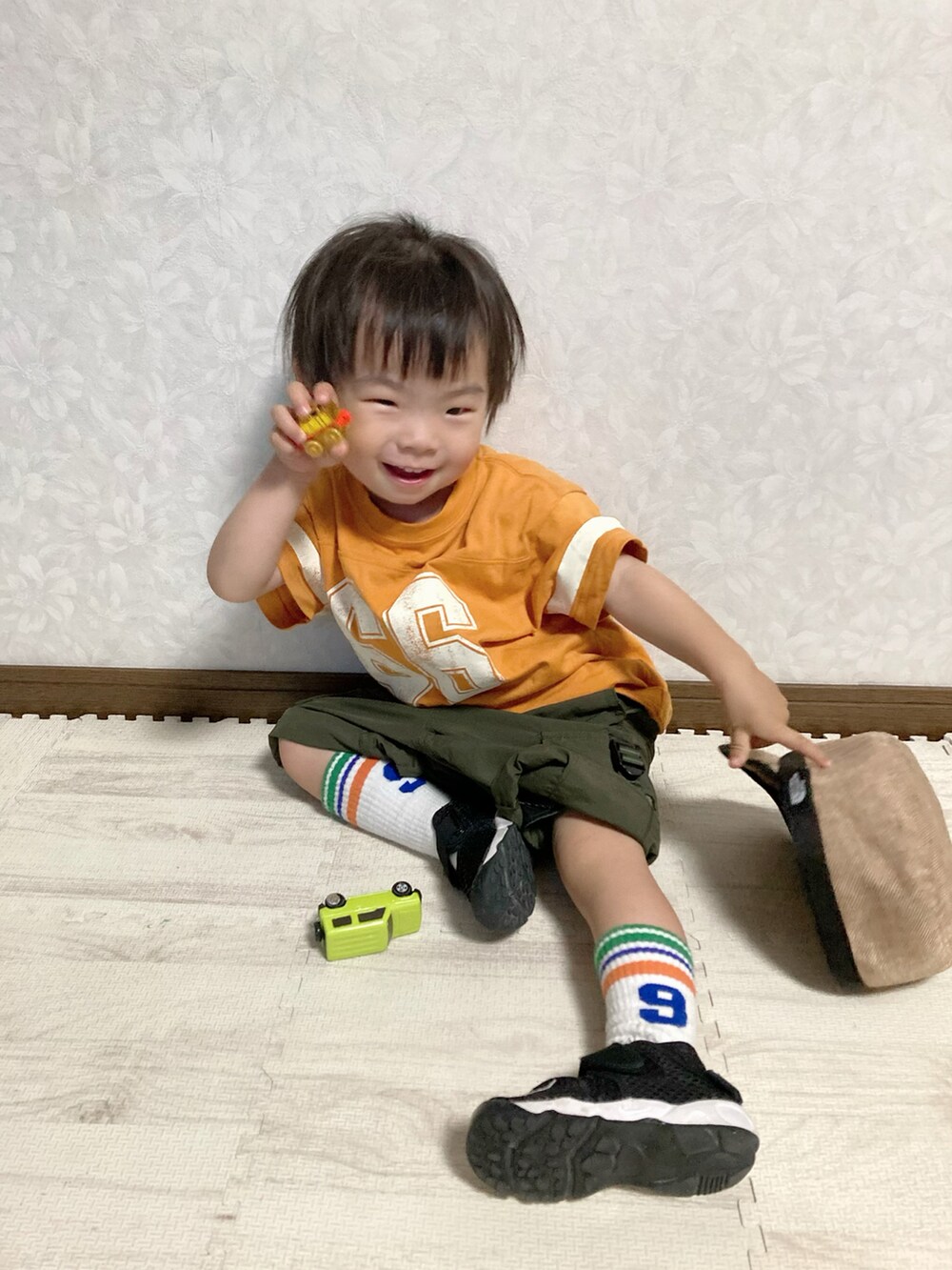オレンジ系のTシャツ/カットソー、グリーン系のカーゴパンツ、ブラック系のスニーカーを着用したキッズの夏コーディネートの3枚目の写真