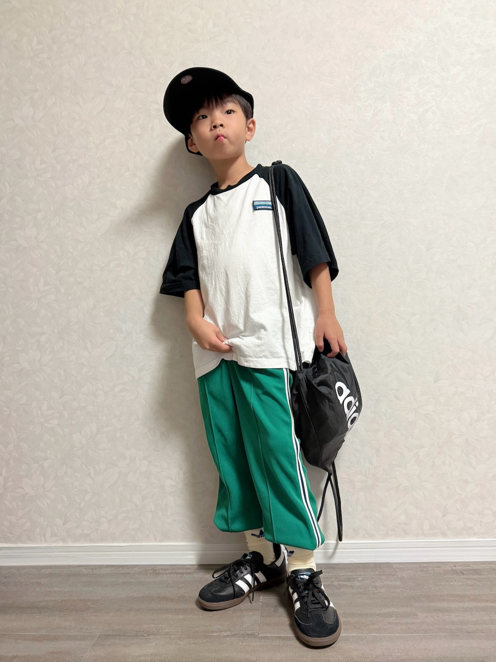 ホワイト系のTシャツ/カットソー、ブラック系のバックパック/リュック、グリーン系のスウェットパンツを着用したキッズの秋コーディネートの2枚目の写真