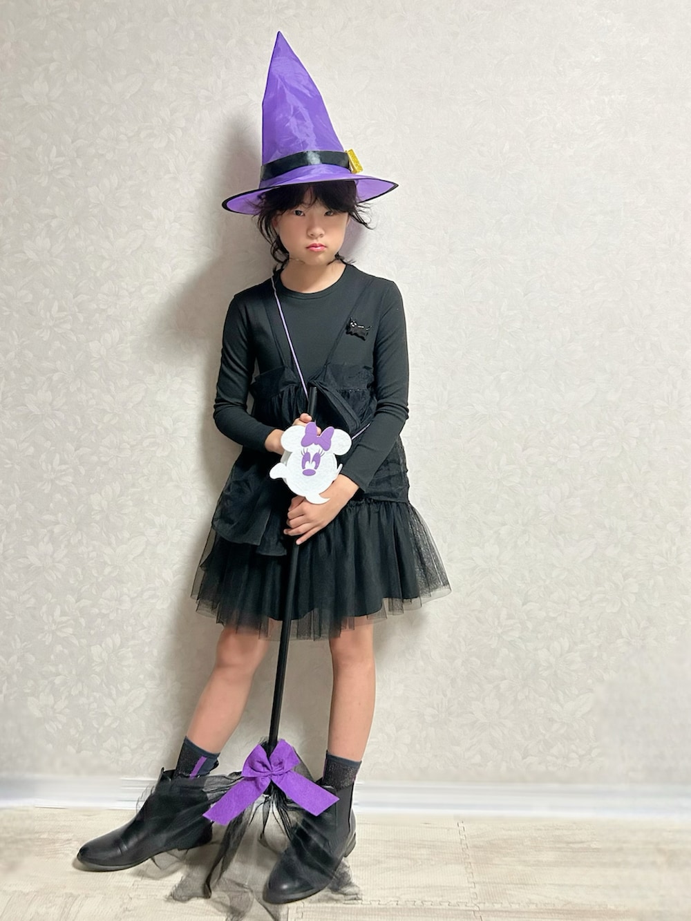 ブラック系のワンピース、ブラック系のブーツ、ブラック系のブローチ/コサージュを着用したキッズの秋コーディネートの2枚目の写真