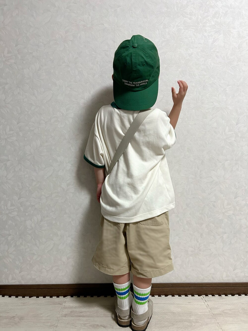ホワイト系のTシャツ/カットソー、ホワイト系のショルダーバッグ、ベージュ系のチノパンツを着用したキッズの春コーディネートの5枚目の写真