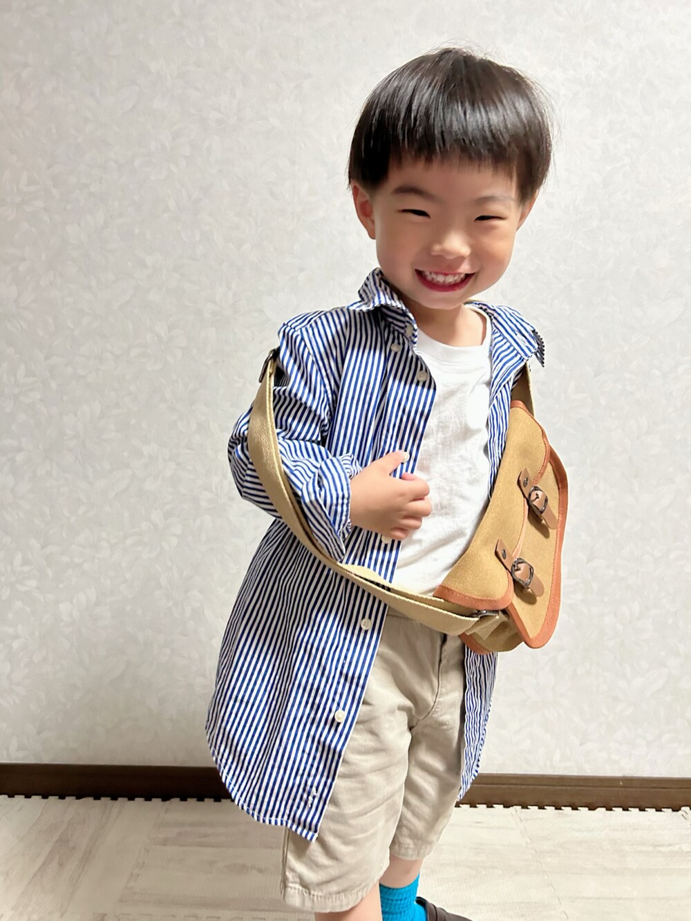 ブルー系のシャツ/ブラウス、ホワイト系のTシャツ/カットソー、ベージュ系のチノパンツを着用したキッズの夏コーディネートの3枚目の写真