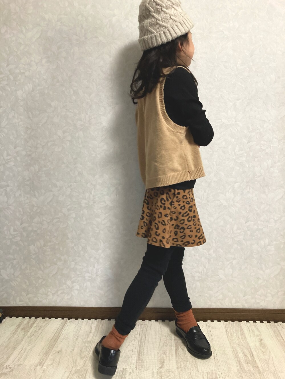 ブラック系のニット/セーター、ベージュ系のベスト、ブラウン系のスカートを着用したキッズの冬コーディネートの5枚目の写真
