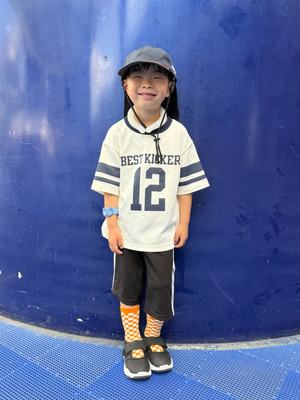 ブラック系のサンダル、ブラック系のパンツ、オレンジ系のソックス/靴下を着用したキッズの夏コーディネートの2枚目の写真