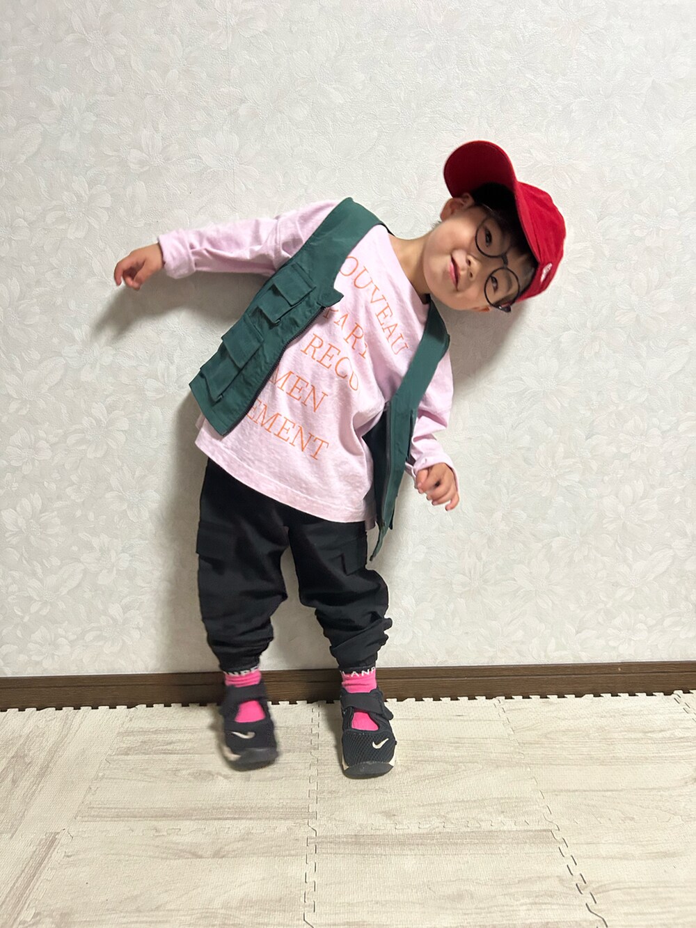 ピンク系のTシャツ/カットソー、グリーン系のベスト、ブラック系のショルダーバッグを着用したキッズの春コーディネートの3枚目の写真