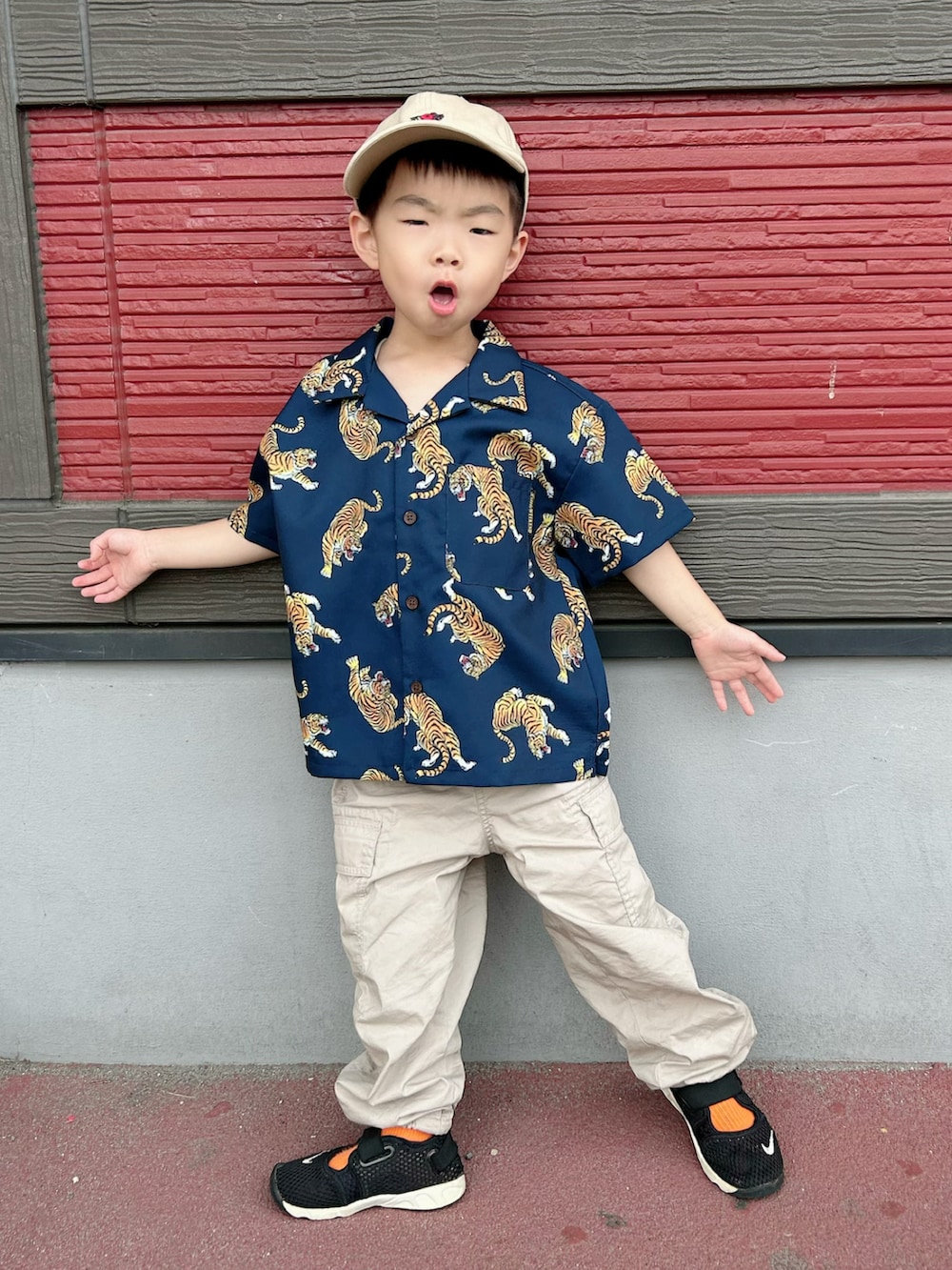 ブルー系のシャツ/ブラウス、ベージュ系のカーゴパンツ、ブラック系のスニーカーを着用したキッズの春コーディネートの2枚目の写真