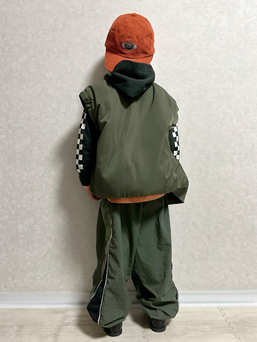 オレンジ系のTシャツ/カットソー、ブラック系のパーカー、グリーン系のMA-1を着用したキッズの秋コーディネートの5枚目の写真