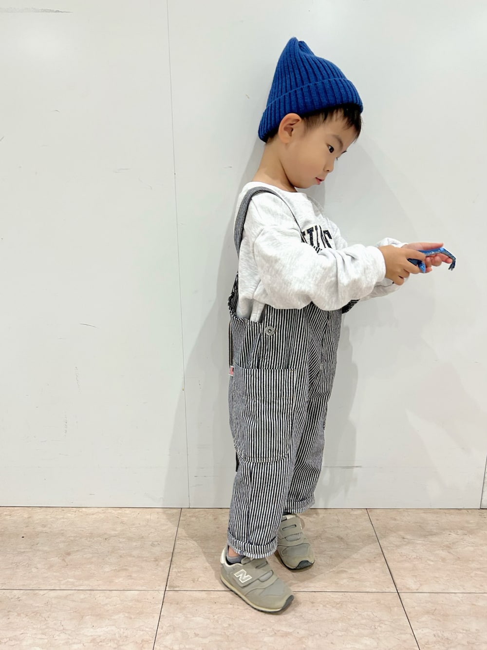 グレー系のスウェット、ブラック系のカーディガン/ボレロ、ホワイト系のショルダーバッグを着用したキッズの秋コーディネートの4枚目の写真