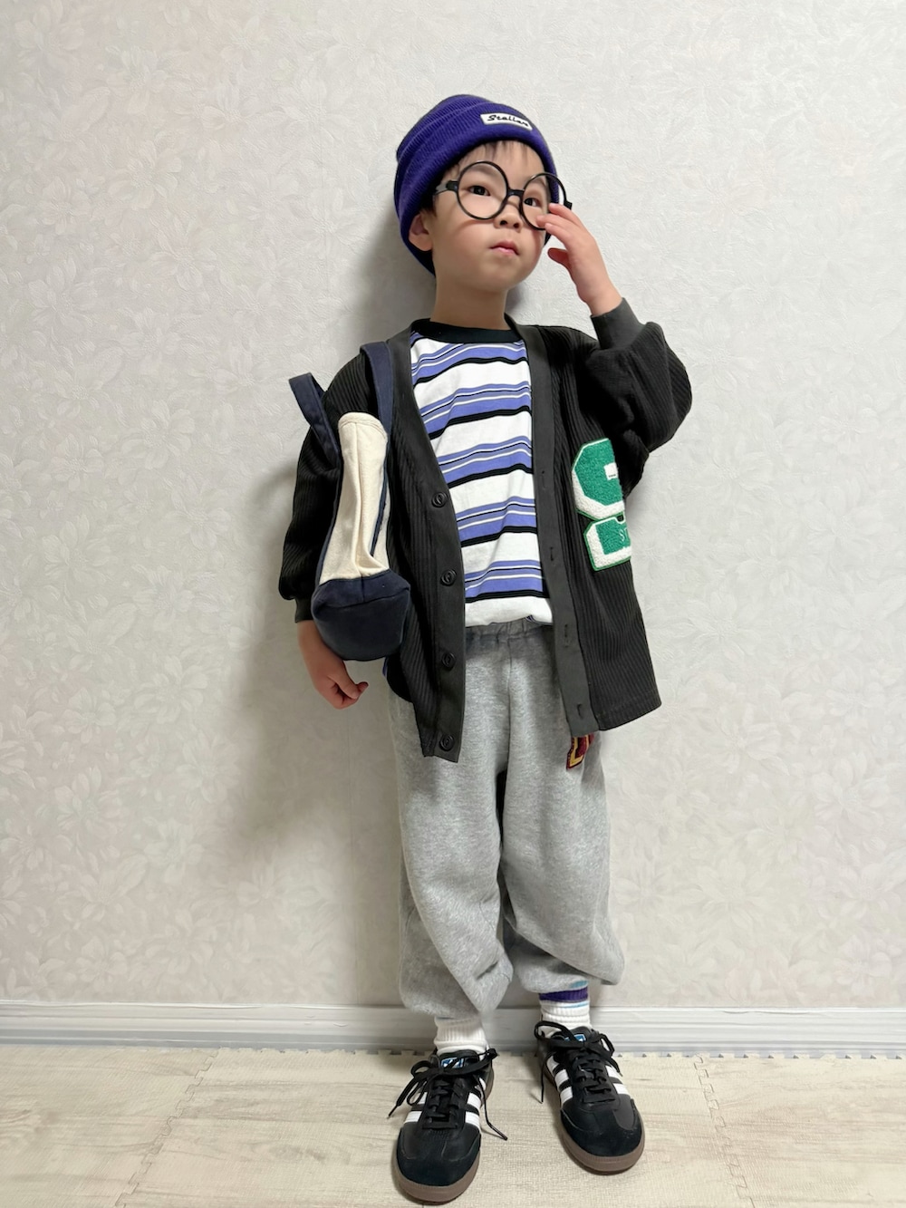 パープル系のTシャツ/カットソー、ブラック系のカーディガン/ボレロ、グレー系のスウェットパンツを着用したキッズの春コーディネートの3枚目の写真