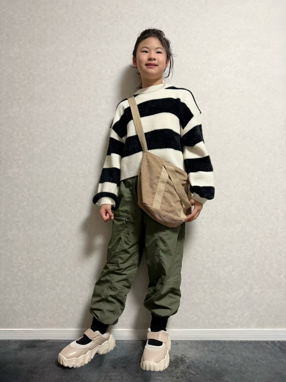 ベージュ系のその他シューズ、ホワイト系のニット/セーター、ブラウン系のジャケット/アウターを着用したキッズの冬コーディネートの2枚目の写真