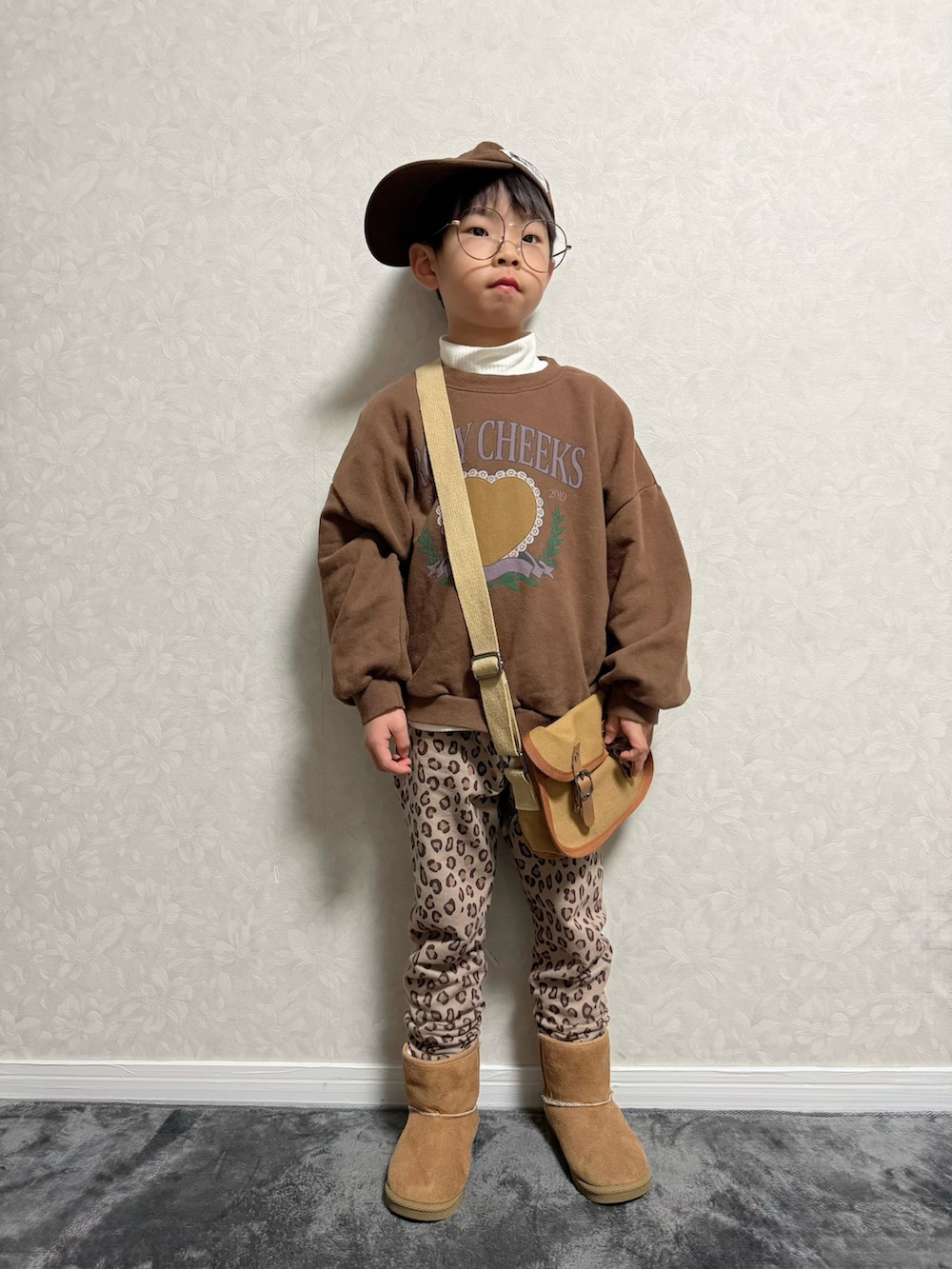 ブラウン系のその他パンツ、ブラウン系のショルダーバッグ、ホワイト系のTシャツ/カットソーを着用したキッズの冬コーディネートの2枚目の写真