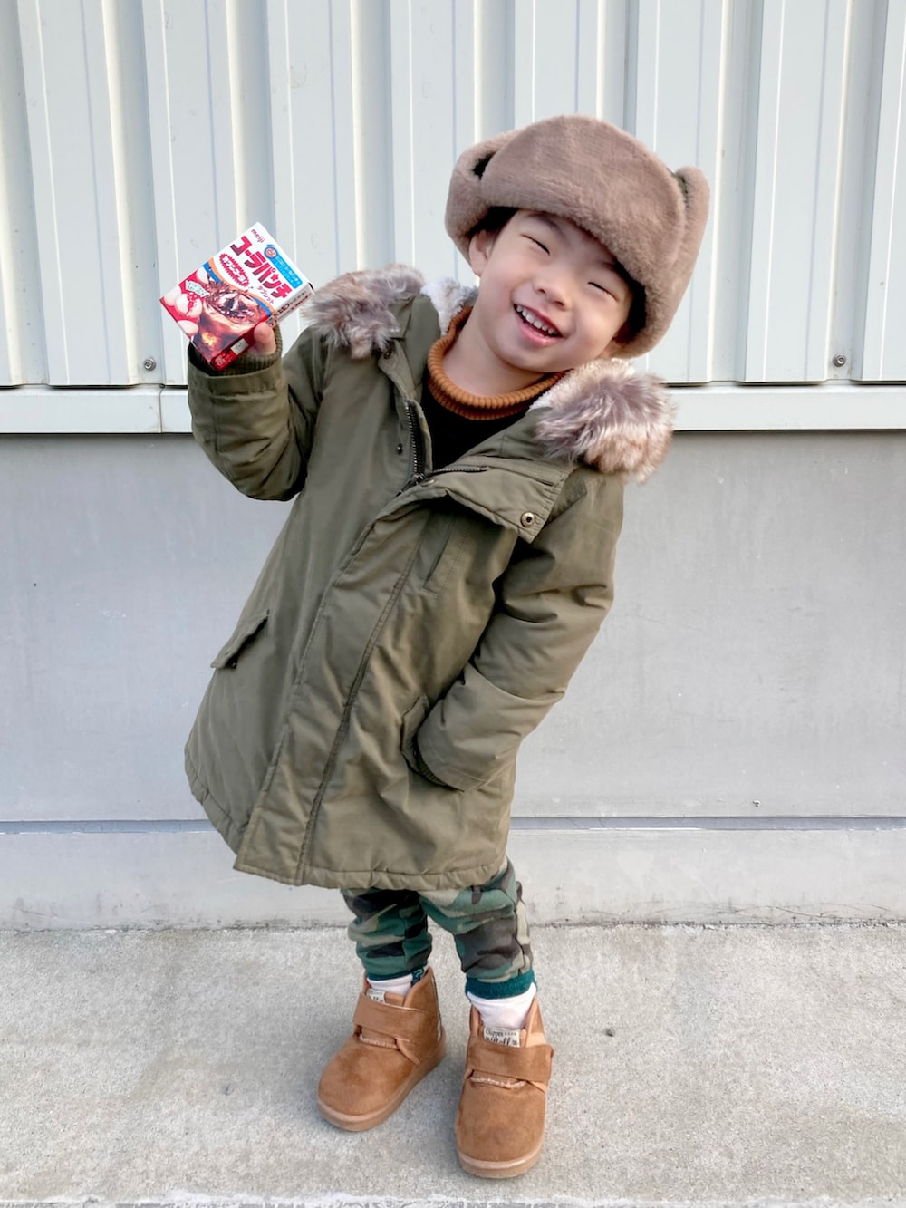 イエロー系のニット/セーター、ブラック系のTシャツ/カットソー、グリーン系のモッズコートを着用したキッズの冬コーディネートの2枚目の写真