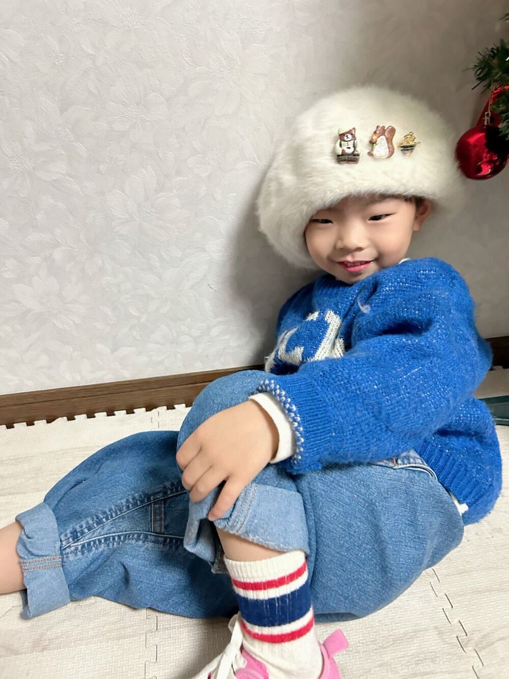 ブルー系のニット/セーター、ブルー系のデニムパンツ、ピンク系のスニーカーを着用したキッズの冬コーディネートの4枚目の写真