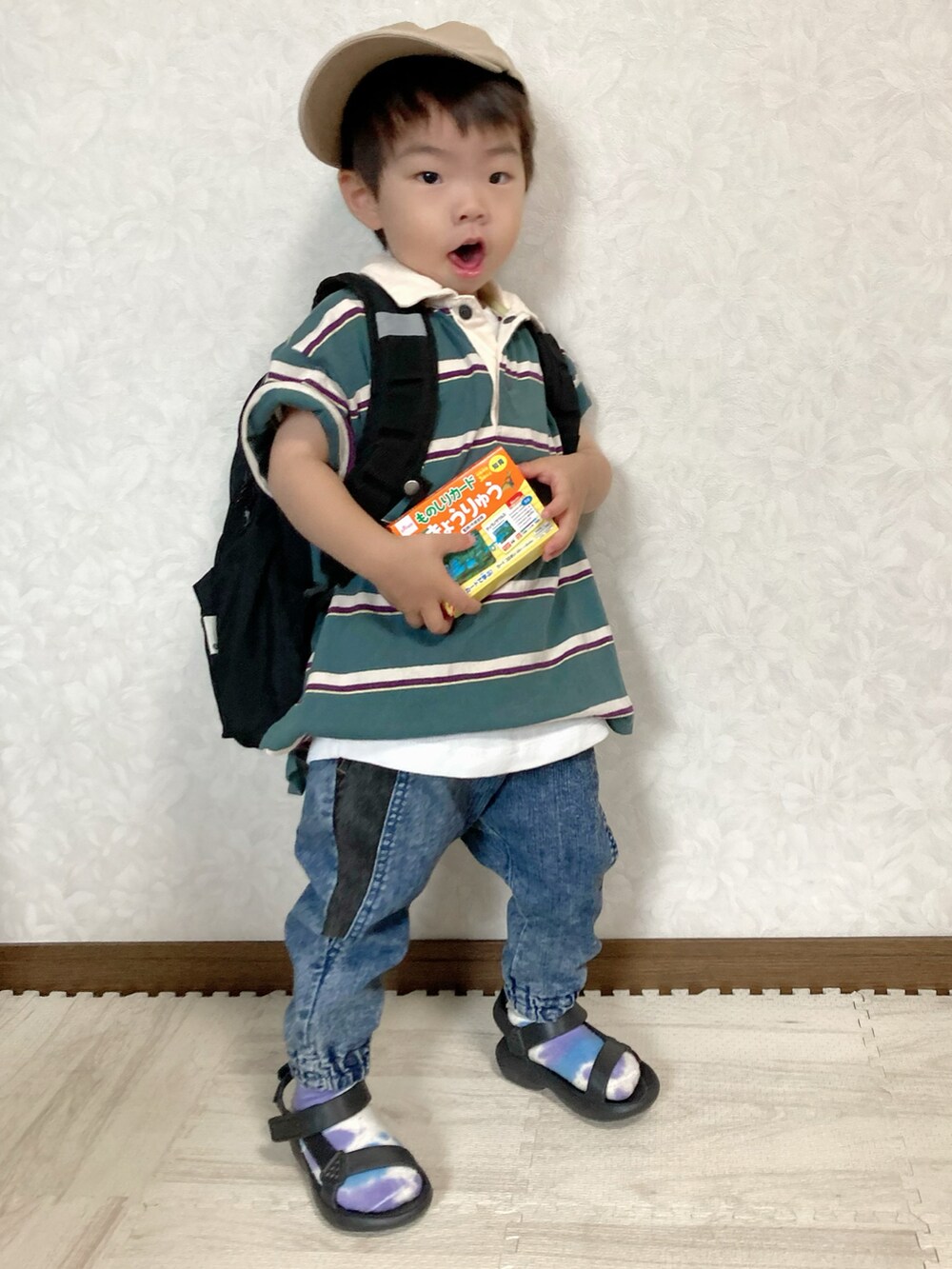 グリーン系のポロシャツ、ブルー系のデニムパンツ、ブラック系のバックパック/リュックを着用したキッズの夏コーディネートの2枚目の写真