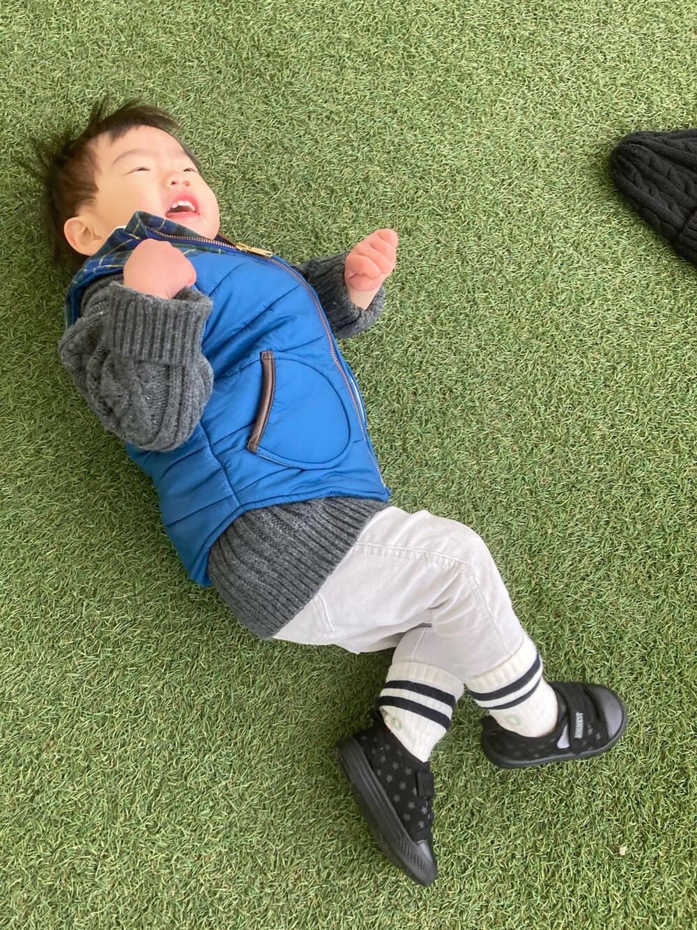 グレー系のスウェット、グレー系のカーディガン/ボレロ、ブルー系のダウンベストを着用したキッズの冬コーディネートの5枚目の写真