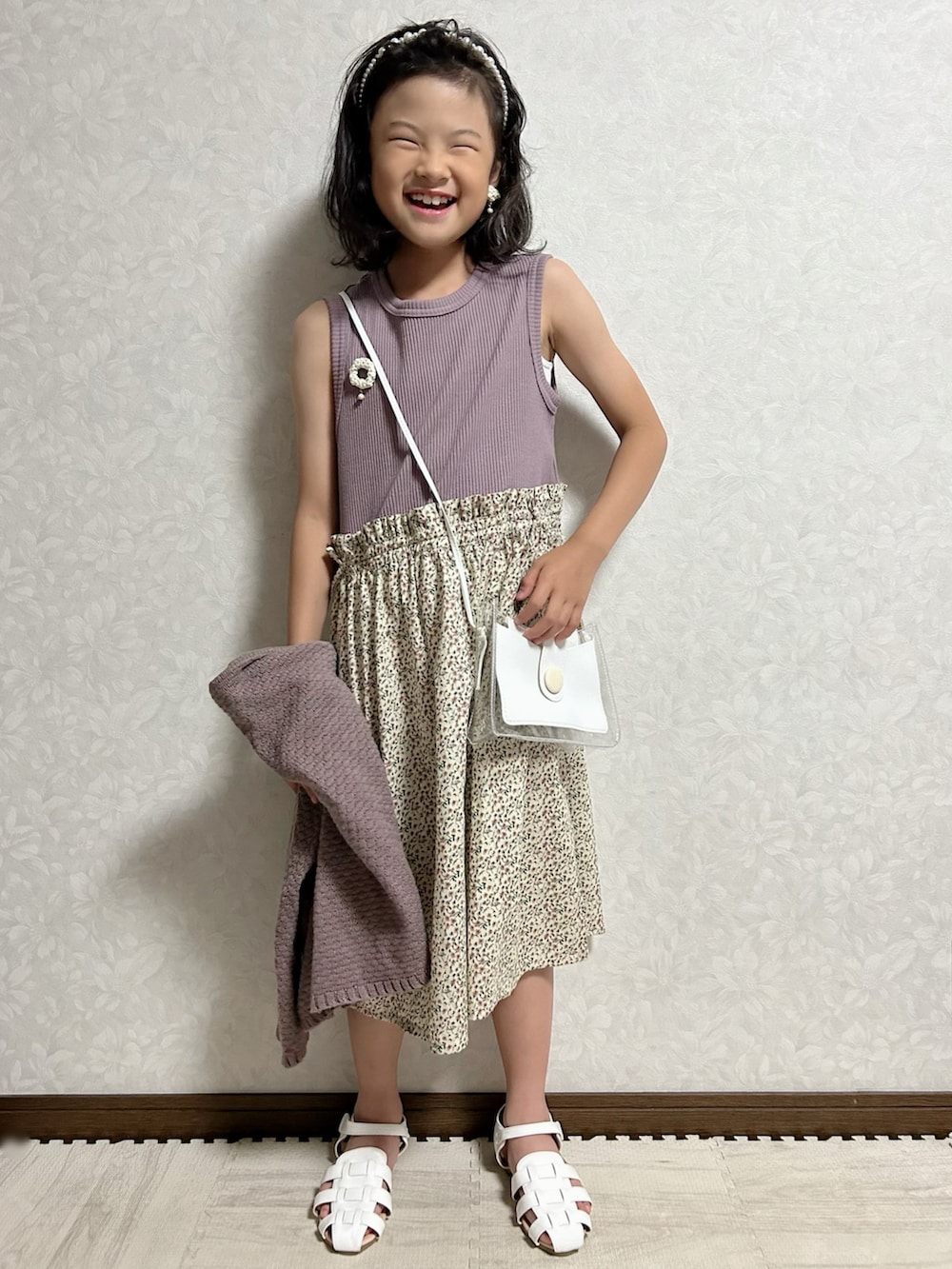 パープル系のワンピース、グレー系のカーディガン/ボレロ、ホワイト系のショルダーバッグを着用したキッズの夏コーディネートの4枚目の写真