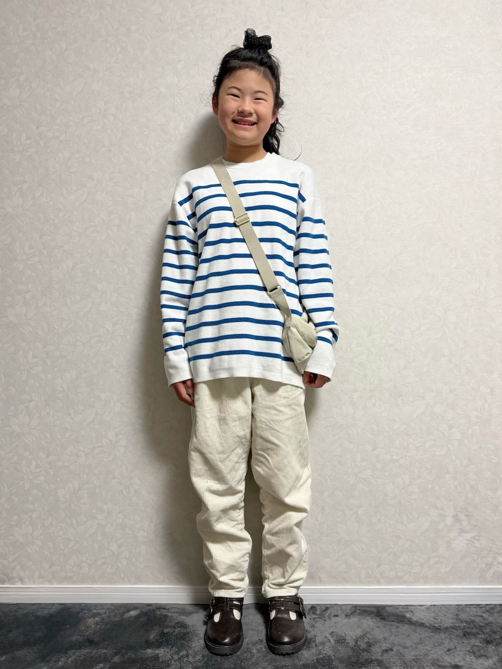 ブラウン系のその他シューズ、ホワイト系のニット/セーター、ベージュ系のステンカラーコートを着用したキッズの冬コーディネートの4枚目の写真