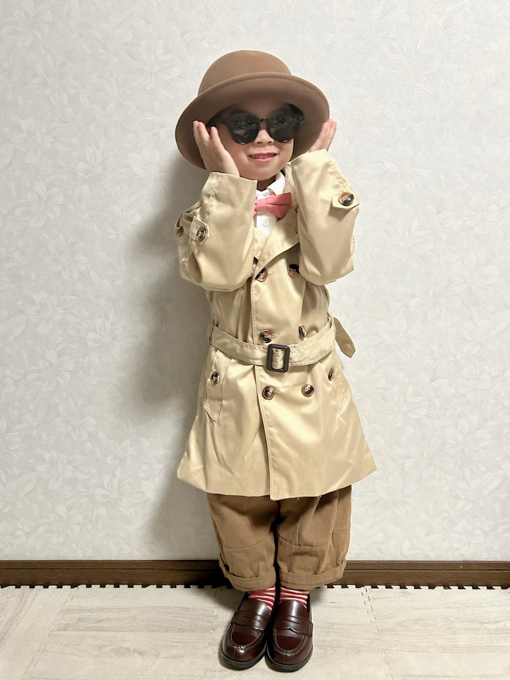 ホワイト系のシャツ/ブラウス、ベージュ系のトレンチコート、ブラウン系のチノパンツを着用したキッズの秋コーディネートの3枚目の写真