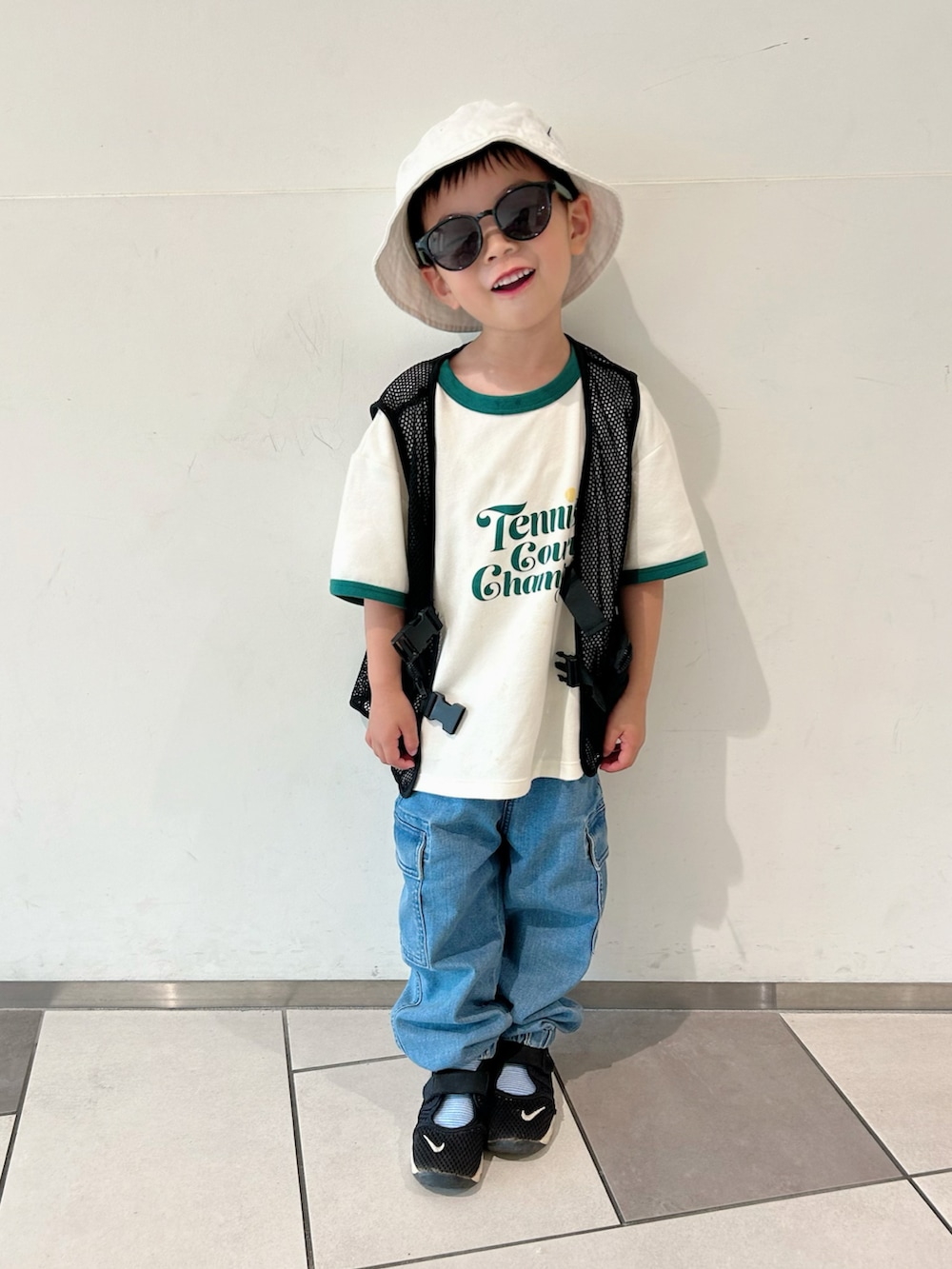 ホワイト系のTシャツ/カットソー、ブラック系のベスト、ブルー系のデニムパンツを着用したキッズの春コーディネートの2枚目の写真