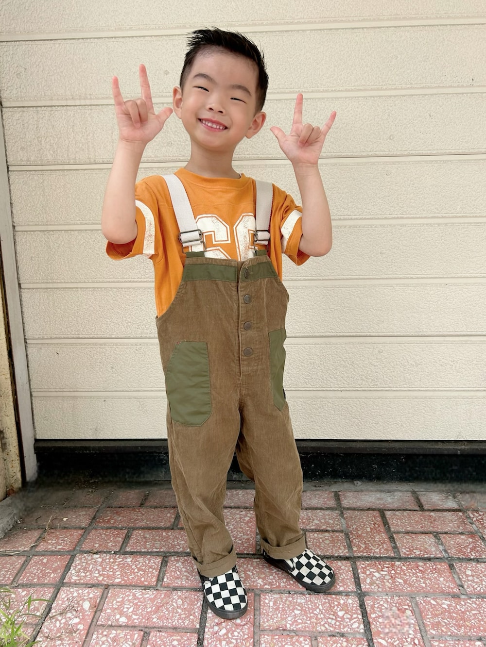 オレンジ系のTシャツ/カットソー、グリーン系のサロペット/オーバーオール、その他のスリッポンを着用したキッズの秋コーディネートの2枚目の写真