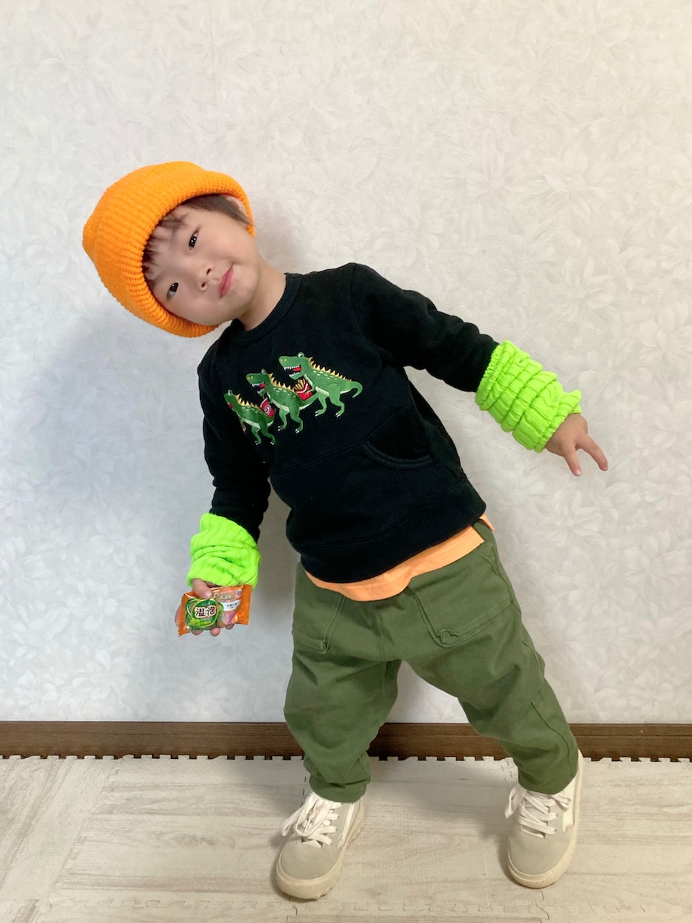 ブラック系のスウェット、オレンジ系のタンクトップ、グリーン系のパンツを着用したキッズの秋コーディネートの3枚目の写真