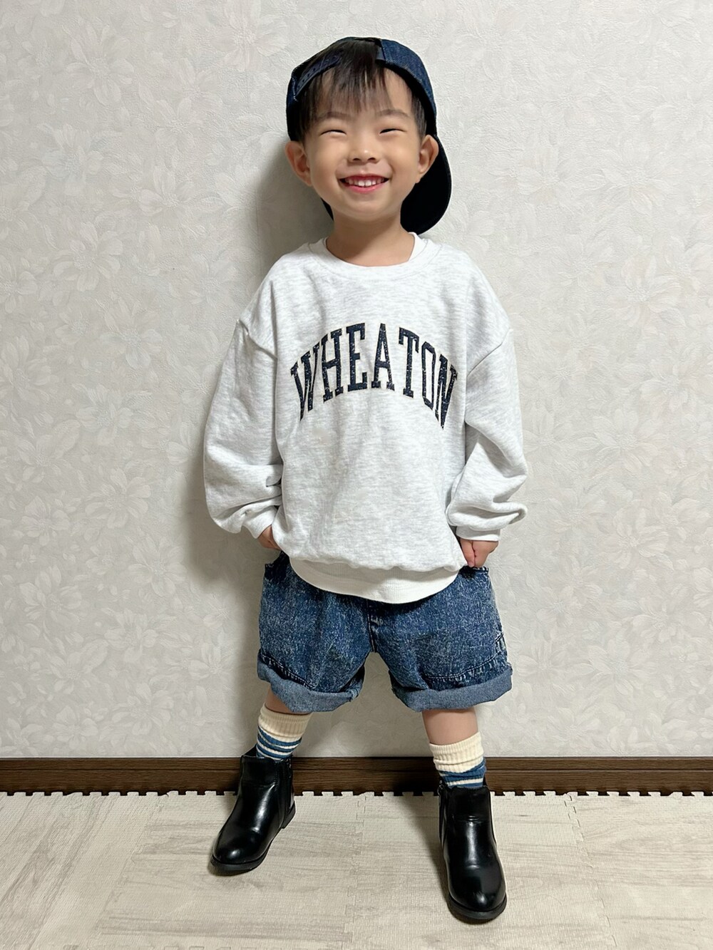 グレー系のスウェット、ブルー系のデニムパンツ、ブラック系のブーツを着用したキッズの秋コーディネートの2枚目の写真