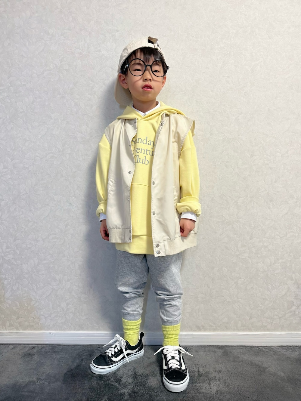 ベージュ系のベスト、グレー系のスウェットパンツ、シルバー系のショルダーバッグを着用したキッズの冬コーディネートの3枚目の写真