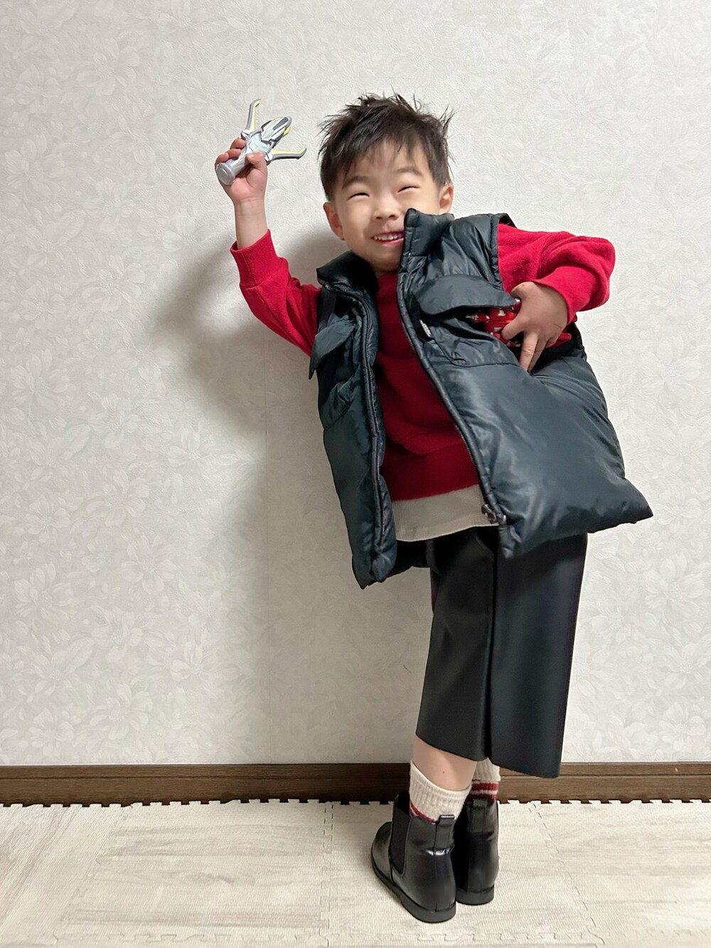 ブラック系のパンツ、レッド系のスウェット、ブラック系のブーツを着用したキッズの冬コーディネートの5枚目の写真