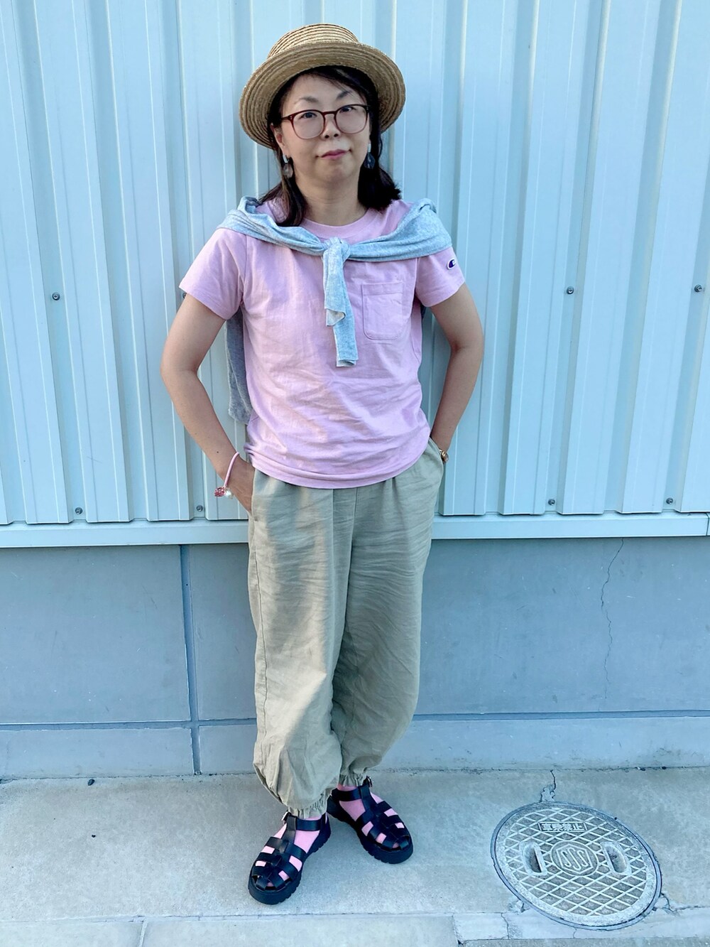 ピンク系のTシャツ/カットソー、グレー系のカーディガン/ボレロ、ベージュ系のパンツを着用したレディースの夏コーディネートの2枚目の写真