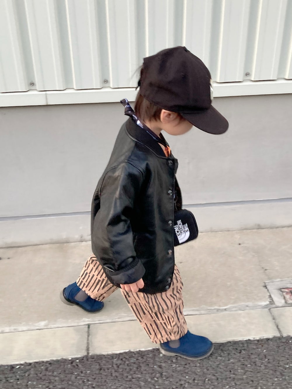 ブラウン系のジャケット/アウター、ブラック系のスカート、ブラック系のブーツを着用したキッズの秋コーディネートの5枚目の写真