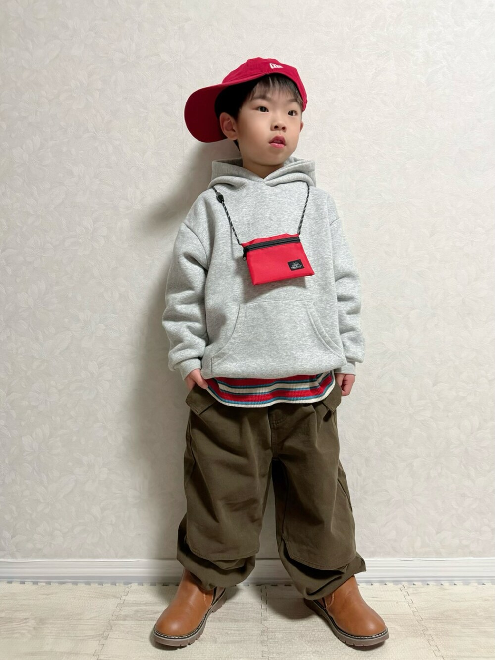 グレー系のパーカー、レッド系のTシャツ/カットソー、ブラウン系のショルダーバッグを着用したキッズの春コーディネートの3枚目の写真