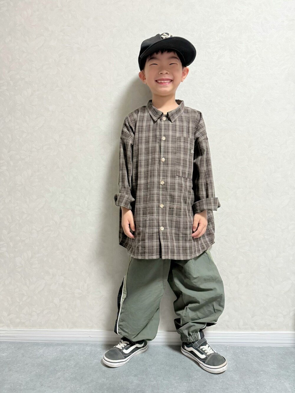 ブラウン系のシャツ/ブラウス、グリーン系のその他パンツ、ブラック系のスニーカーを着用したキッズの秋コーディネートの3枚目の写真