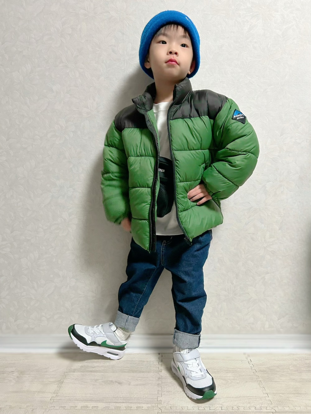ホワイト系のTシャツ/カットソー、グリーン系のダウンジャケット/コート、ブルー系のデニムパンツを着用したキッズの冬コーディネートの3枚目の写真