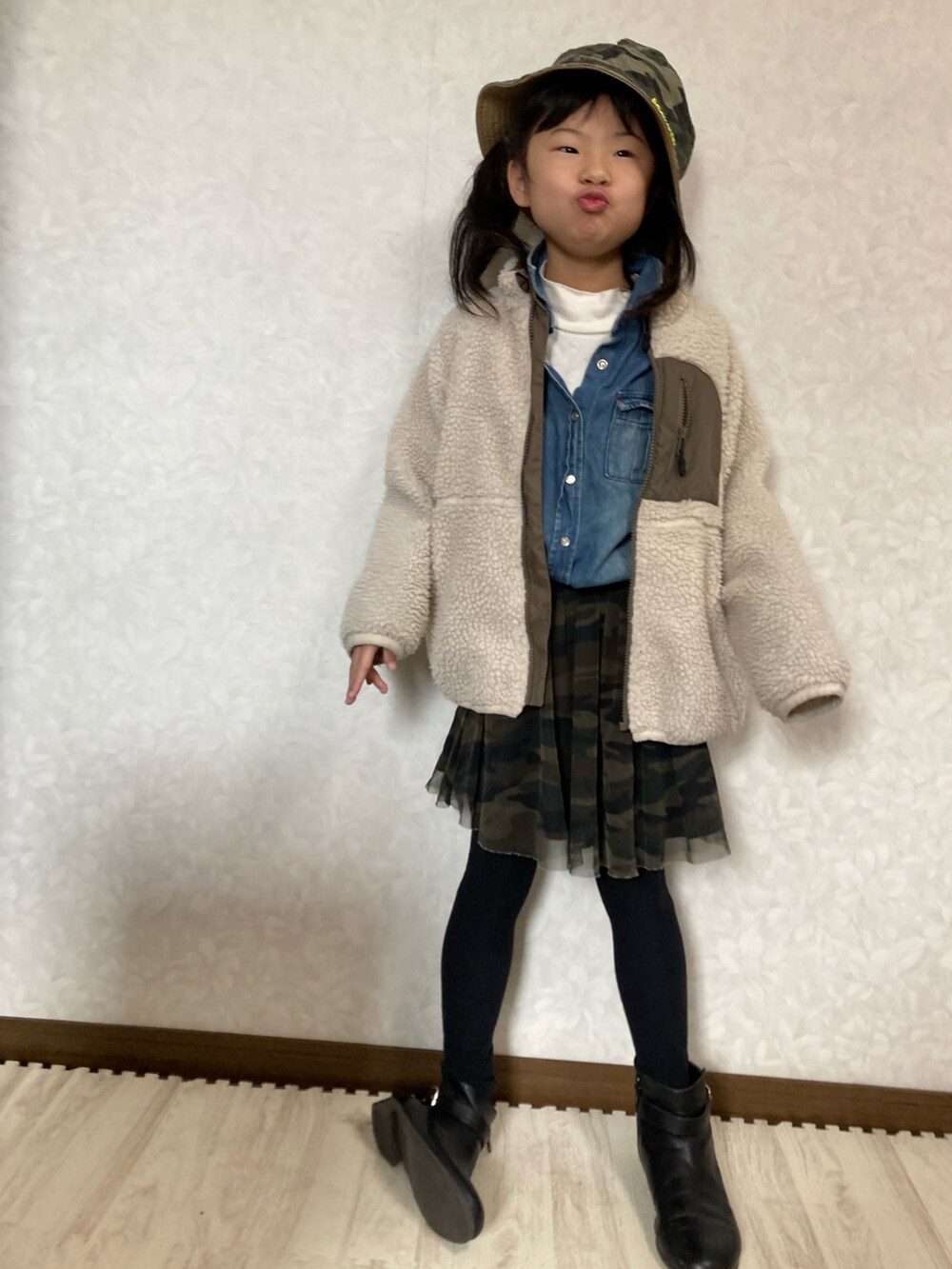 ホワイト系のニット/セーター、ブルー系のシャツ/ブラウス、グリーン系のスカートを着用したキッズの冬コーディネートの3枚目の写真