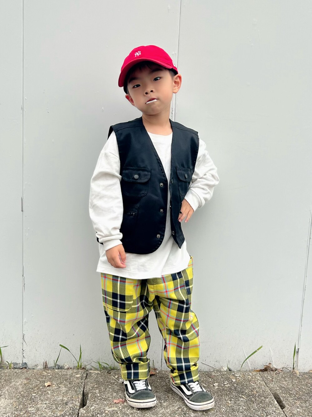 ホワイト系のTシャツ/カットソー、ブラック系のベスト、レッド系のスタジャンを着用したキッズの秋コーディネートの5枚目の写真