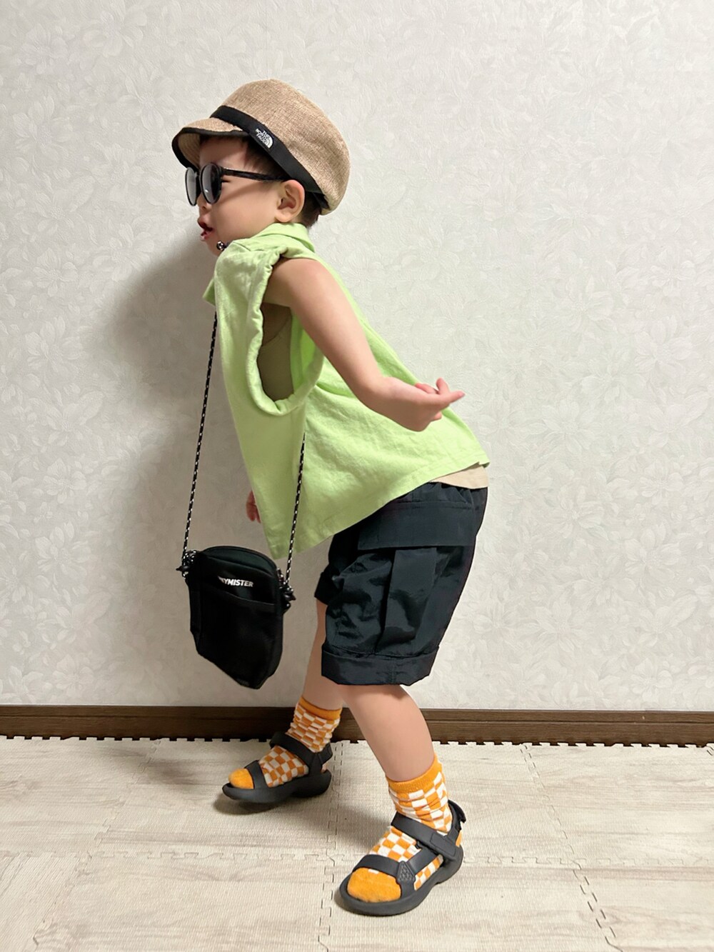 ベージュ系のタンクトップ、グリーン系のポロシャツ、ブラック系のカーゴパンツを着用したキッズの夏コーディネートの4枚目の写真