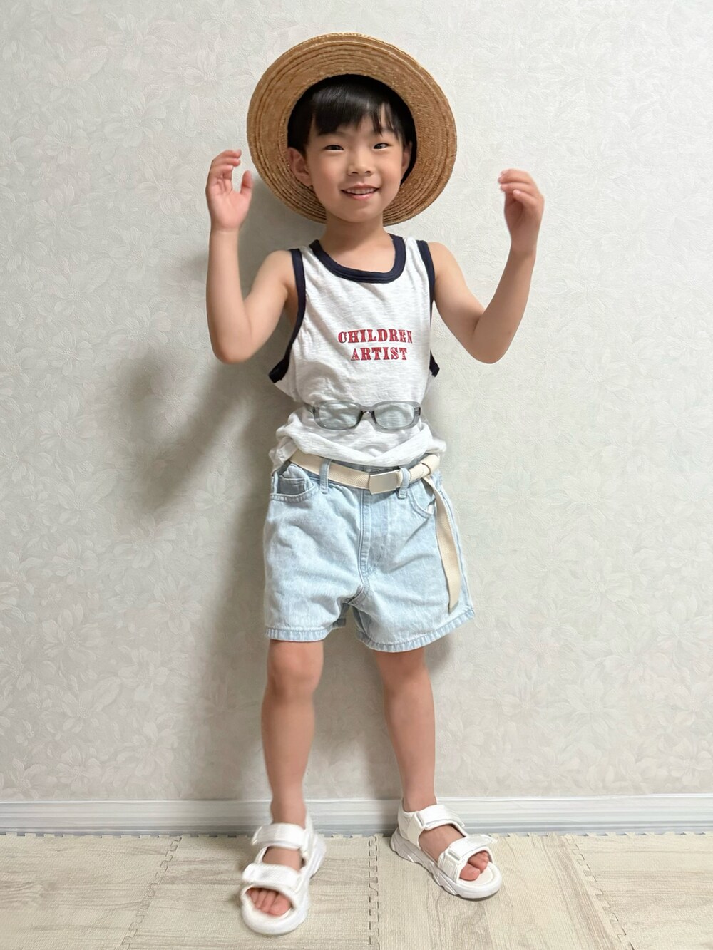 ホワイト系のタンクトップ、ブルー系のデニムパンツ、ホワイト系のサンダルを着用したキッズの夏コーディネートの4枚目の写真