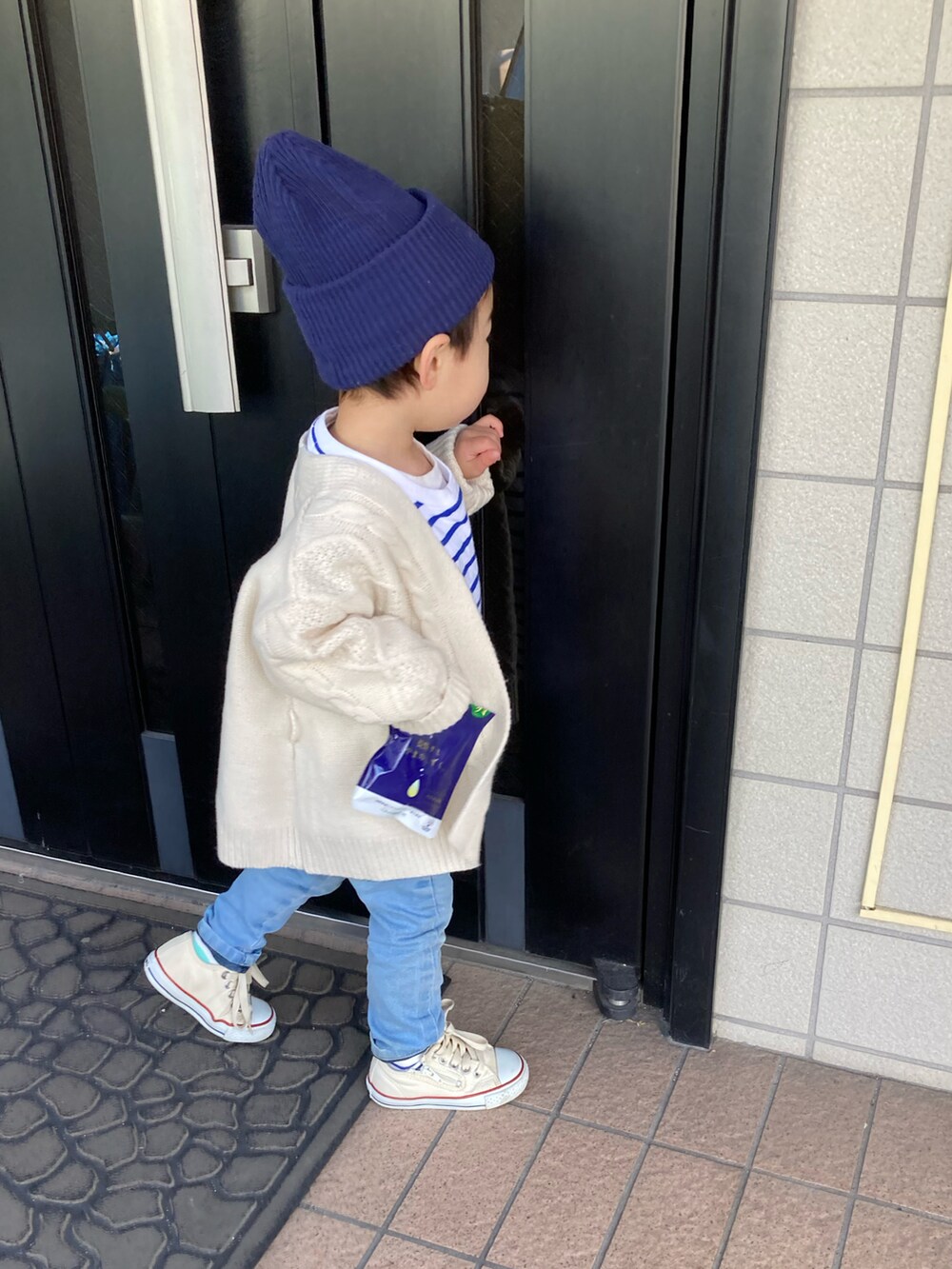 ブルー系のTシャツ/カットソー、ホワイト系のカーディガン/ボレロ、ブルー系のデニムパンツを着用したキッズの冬コーディネートの5枚目の写真