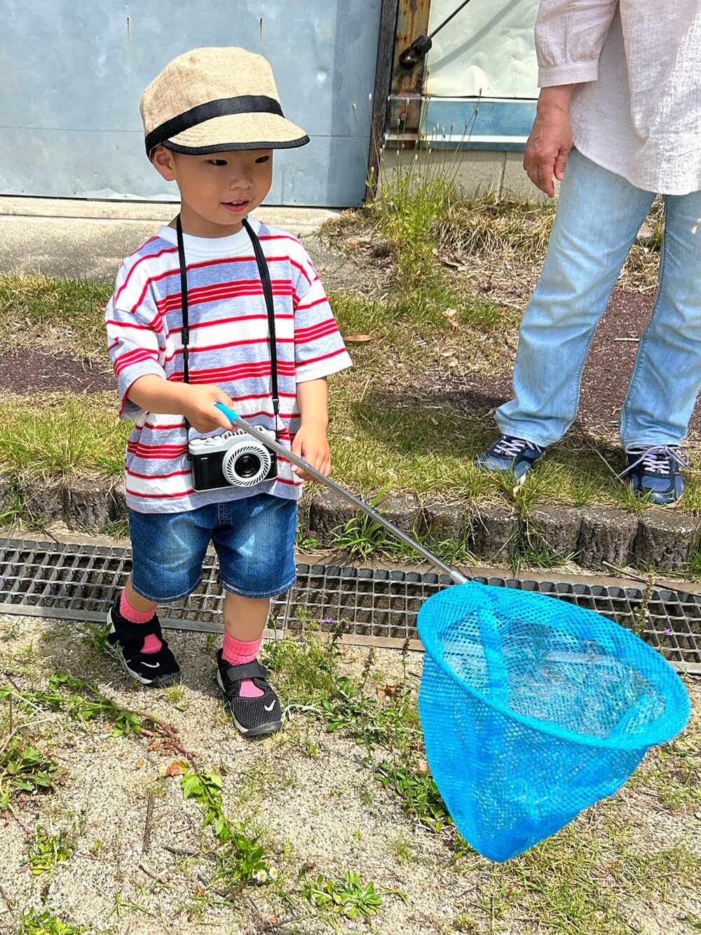 グレー系のTシャツ/カットソー、ブルー系のデニムパンツ、ブラック系のスニーカーを着用したキッズの春コーディネートの4枚目の写真