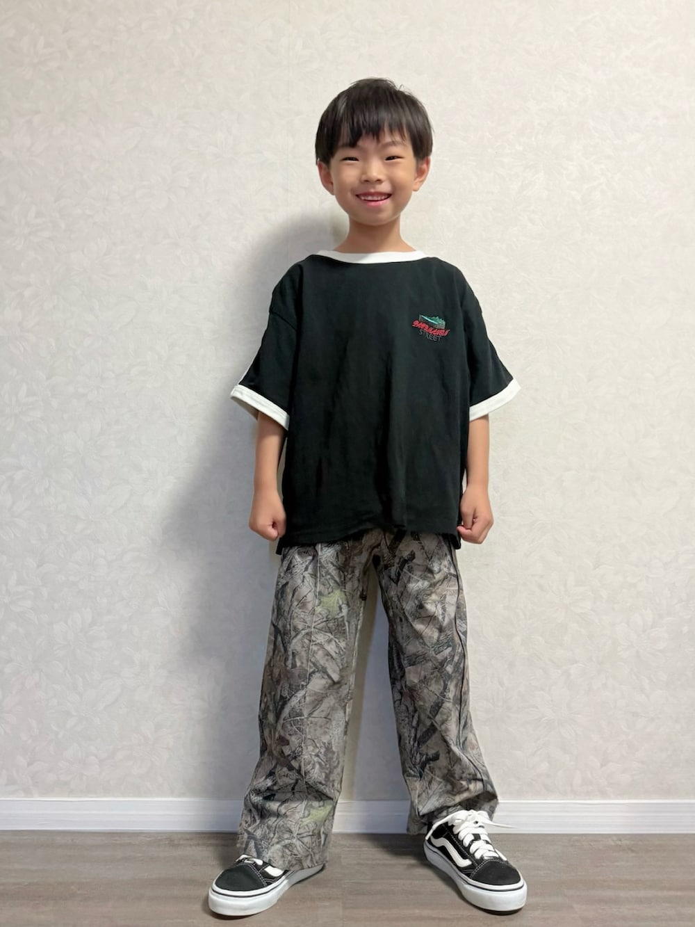 ブラック系のセットアップ、ベージュ系のその他パンツ、ブラック系のスニーカーを着用したキッズの夏コーディネートの3枚目の写真