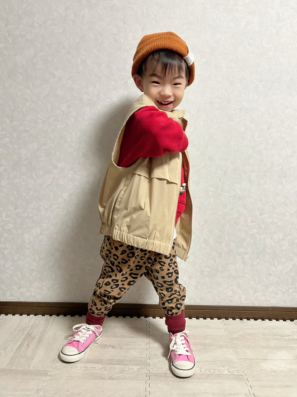 ベージュ系のベスト、レッド系のスウェット、ブラウン系のスウェットパンツを着用したキッズの冬コーディネートの3枚目の写真