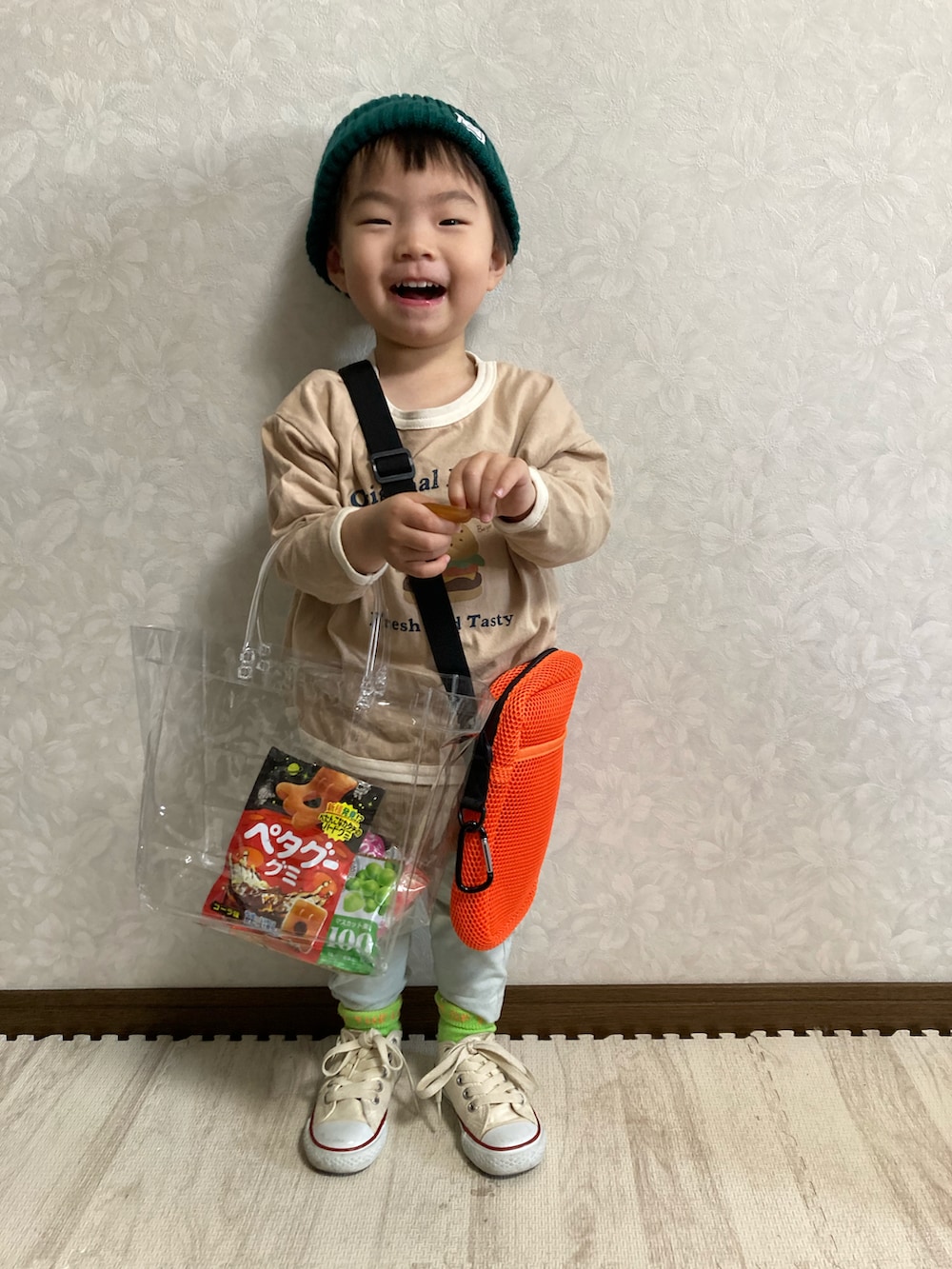 ベージュ系のTシャツ/カットソー、グリーン系のパンツ、オレンジ系のショルダーバッグを着用したキッズの春コーディネートの5枚目の写真