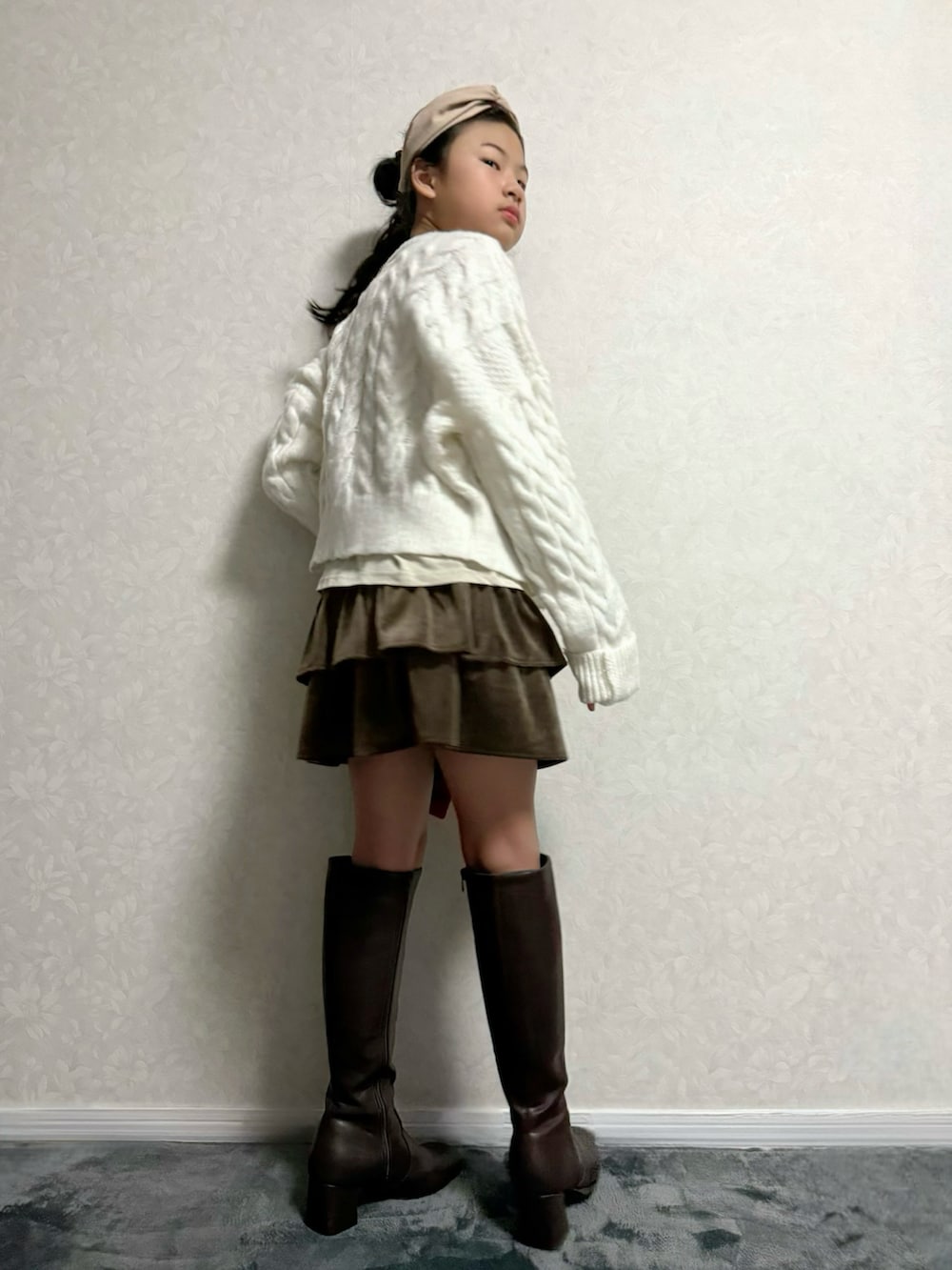 ホワイト系のカーディガン/ボレロ、ベージュ系のTシャツ/カットソー、ブラウン系のブーツを着用したキッズの秋コーディネートの3枚目の写真