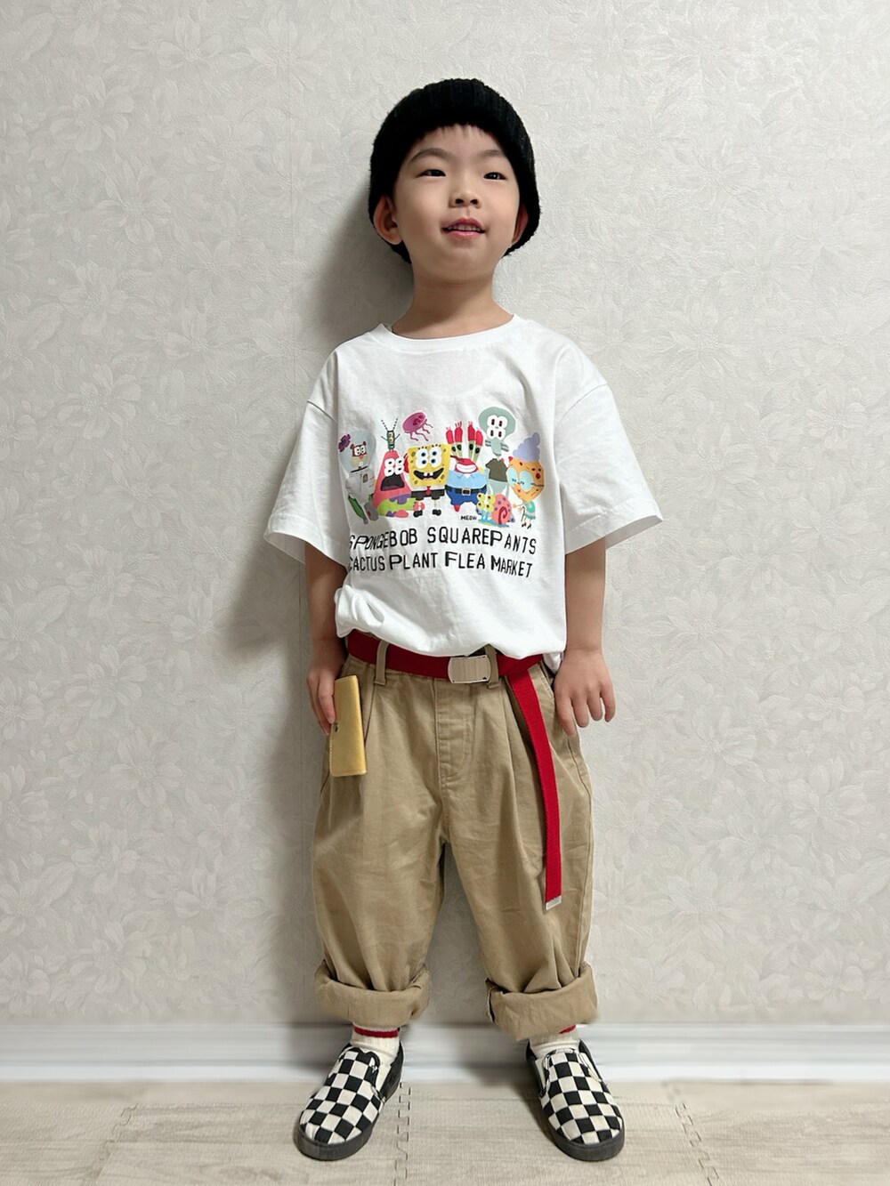 ホワイト系のTシャツ/カットソー、ピンク系のカーディガン/ボレロ、ベージュ系のチノパンツを着用したキッズの冬コーディネートの2枚目の写真